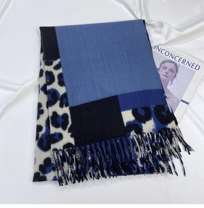 Close-up of leopard print cashmere scarf with blue color-blocking and tassel edges