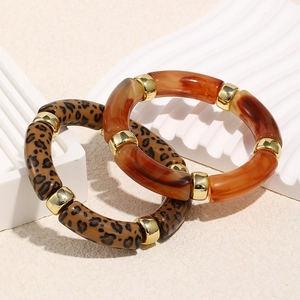 Detail of leopard print and amber resin beaded bracelets with golden metal spacers