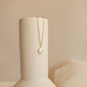 Detail of 14K gold plated paperclip chain featuring a natural baroque pearl pendant