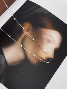 Dettaglio della collana in argento S925 con sfere e cubi su un ritratto femminile