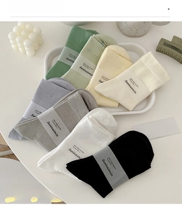 Nahaufnahme farblich sortierter Baumwollsocken, ordentlich gestapelt mit Papierbanderol