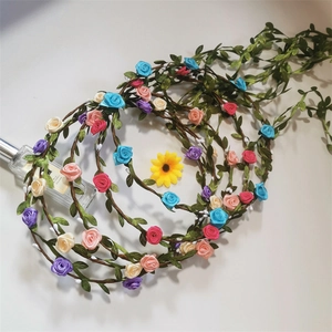 Detailed view of colorful artificial rose headbands with woven green leaves and vines