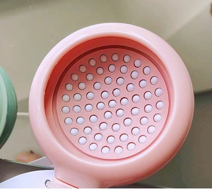 Close-up of pink shower head with silicone nozzles and sleek plastic finish