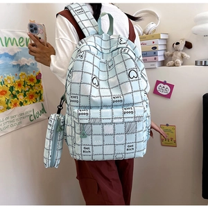 Detail of light blue plaid backpack with cartoon prints and side pencil case attachment