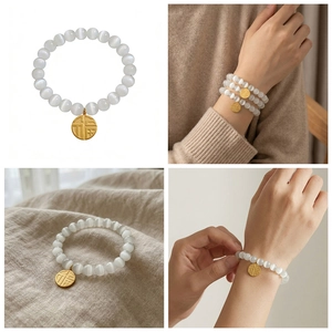 Detail of white cat eye stone bead bracelet with a gold lucky Fu charm in soft light