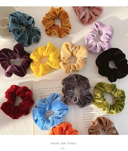 Detailed view of colorful velvet scrunchies set with a soft sheen on white background
