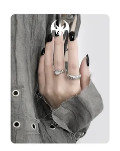 Detailed view of textured silver rings with organic rock patterns and light gemstone