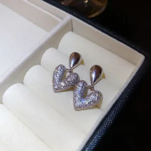 Boucles d'oreilles cœur en argent et zircons pavés dans un écrin en velours blanc