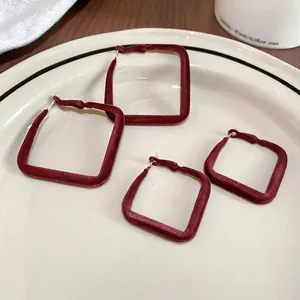 Boucles d'oreilles géométriques en velours marron sur plateau en céramique élégant