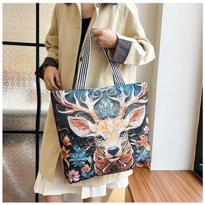 Close-up of artistic 3D floral butterfly embroidery and deer motif on canvas tote bag