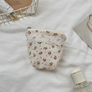 Detail view of floral storage bag with lace trim and silver metal zipper closure