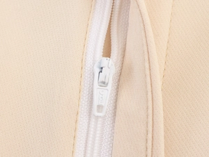 Detail of beige textile fabric featuring a white invisible zipper and fine stitching