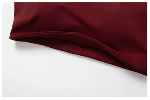 Detailaufnahme des doppelt genähten Saums an dunkelrotem, elastischem Sport-BH-Stoff