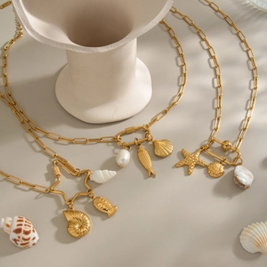 Layered 18K gold titanium steel necklaces with seashell, starfish, and pearl charms