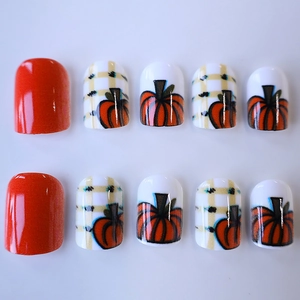 Faux ongles carrés courts avec motifs de citrouille orange et carreaux beige chic