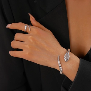 Detailed view of model wearing a silver minimalist snake-shaped bangle and ring set