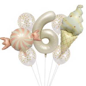 Close-up of beige number 6 balloon with ice cream and candy foil shapes for party decor