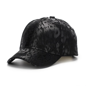 Detail of black faux leather baseball cap featuring textured animal skin pattern embossing