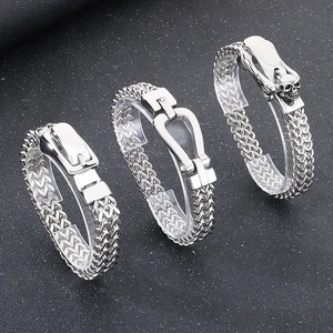 Detailed macro view of woven stainless steel chain bracelets with skull and horseshoe clasps