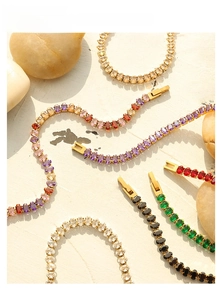 Detailed macro view of gold tennis bracelets with colorful zircon stones on natural stone