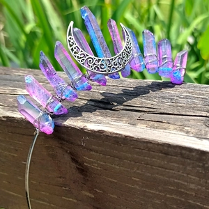 Detail of gradient purple crystal crown with silver crescent moon in outdoor light