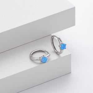 Detailed close-up of S925 silver hoop earrings featuring blue round opal stones on white steps