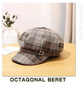 Detail of wool octagonal beret with plaid pattern and golden butterfly buckle