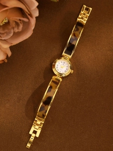 Detailed macro view of retro tortoiseshell chain watch with gold case and Roman numerals