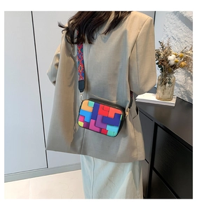 Detail of colorful geometric patchwork crossbody bag with wide shoulder strap
