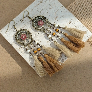 Detail of bohemian long fringe earrings with bronze metal hollow and silk tassels