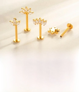 Macro detail of G23 titanium gold leaf labret studs with cubic zirconia marquise stones