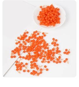 Macro shot of artificial mini orange cherries on a plate for DIY craft and cake decoration