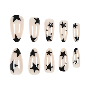 Almond press-on nails with black stars and silver rhinestones on a milky white base
