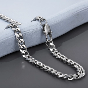 Detail shot of silver stainless steel Cuban link necklace with polished finish and lobster clasp
