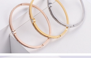 Detail of three stackable hinged bangles with side pavé zircons and a central round stone