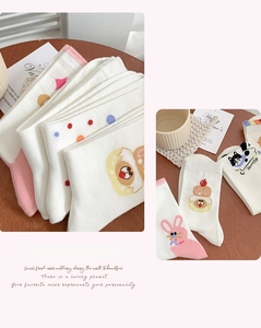 Détail de chaussettes en coton avec motifs mignons de chats, gâteaux et lapins