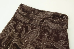 Détail d'une jupe en mousseline paisley marron foncé avec taille plissée et imprimé fin