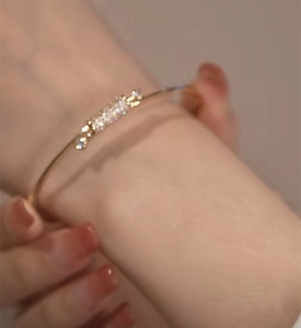 Close-up of elegant gold knot bracelet with sparkling cubic zirconia on a wrist
