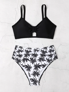 Flachbild von schwarzem Bikini-Oberteil und High-Waist-Hose mit Palmenmuster auf Grau