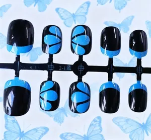 Détail des faux ongles courts carrés bleu et noir avec des reflets argentés brillants