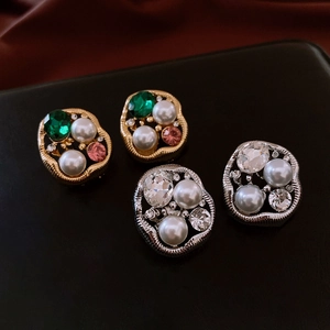 Macro shot of vintage alloy earrings with irregular pearls, rhinestones and gemstones