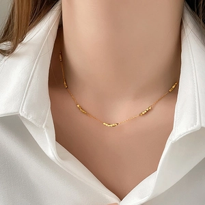 Minimalist gold beaded stainless steel adjustable necklace worn on white shirt