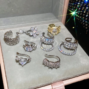 Macro shot of zircon and pearl ear cuff collection in a pink velvet jewelry box