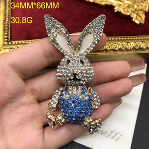 Detailed view of 34mm x 66mm sparkling crystal rabbit brooch with blue enamel details