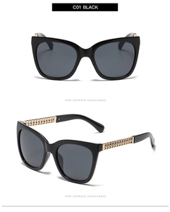 Detail of black cat-eye sunglasses with gold chain metallic temple and grey lenses