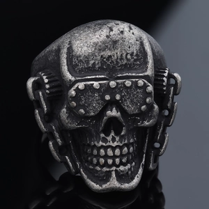 Detailed close-up of retro silver skull ring with steampunk goggles and mechanical gears