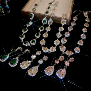 Close-up of teardrop crystal jewelry sets in green, clear, champagne, and pink tones