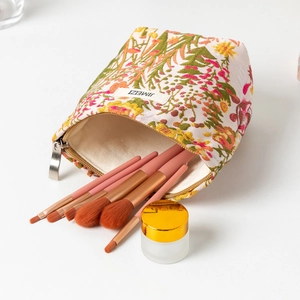 Detail view of floral makeup bag with brushes and cosmetics showing large capacity storage
