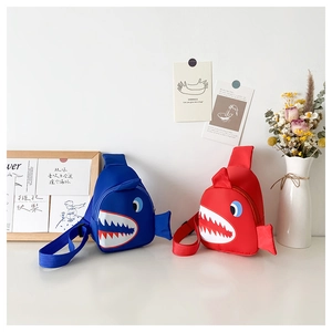 Detail of red and blue shark-shaped children's chest bags with 3D fins and waterproof nylon