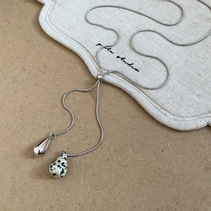 Detail of silver snake chain with adjustable slider bead and spotted stone drop pendant